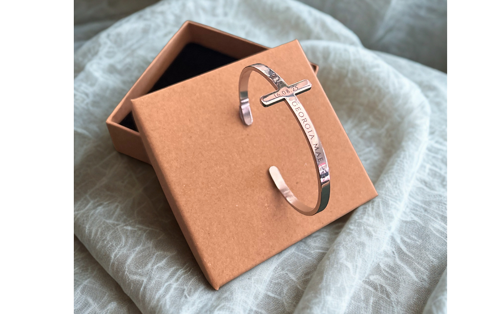 Silver metal stylised cross cuff style bangle with engraving for religious celebration presented on a card gift box