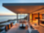 A completed modern luxury home in the Palisades or Malibu, ocean view, high-end finishes, expansive outdoor space with glass walls and open living concept, bathed in golden hour light