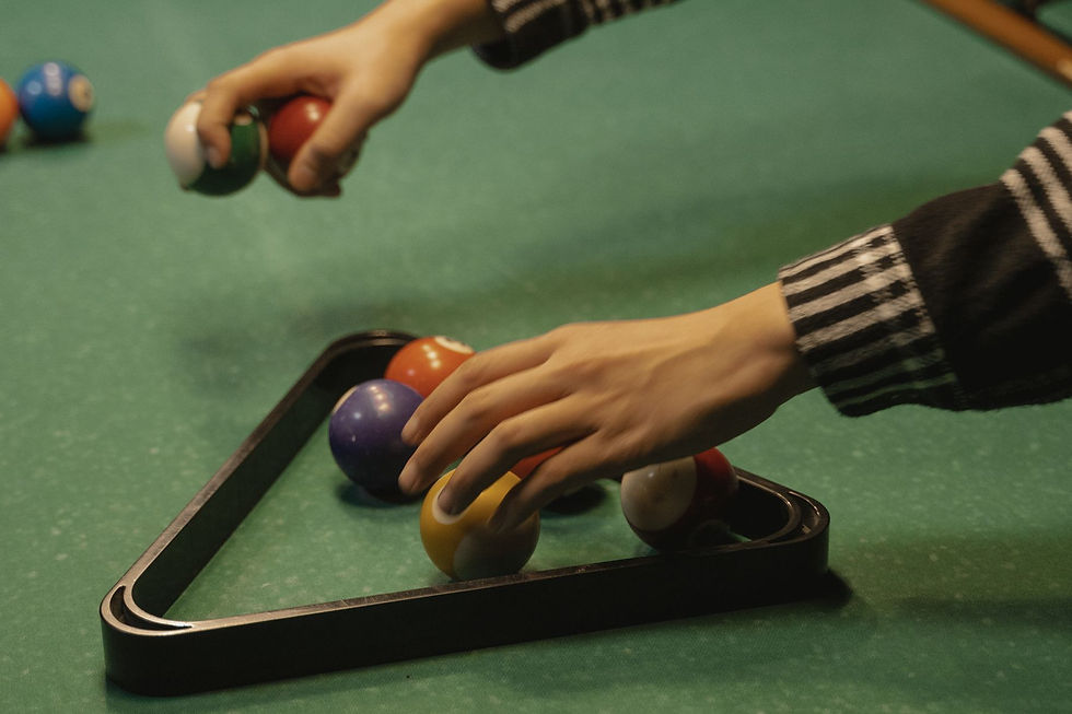 Hand playing billiards on a green table