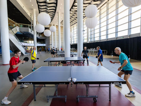 Table tennis being played in a modern indoor venue