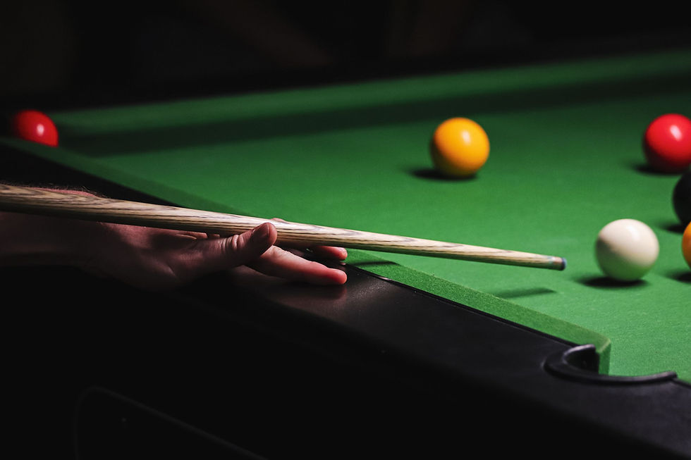 Hand playing billiards on a green table