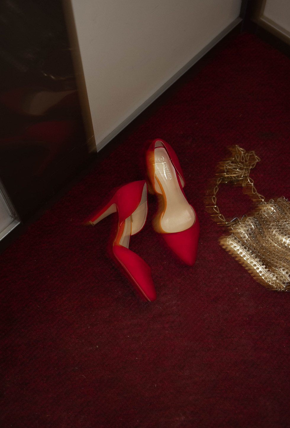 Love Notes - Elegant red heels displayed on burgundy carpet with gold acc - TVS.jpg