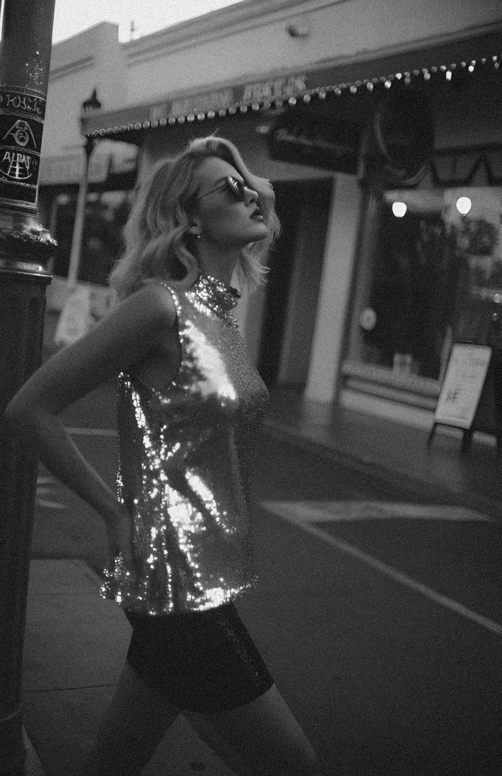 Neural Beauty - Woman in sequined top gazes upward on city street - TVS.jpg