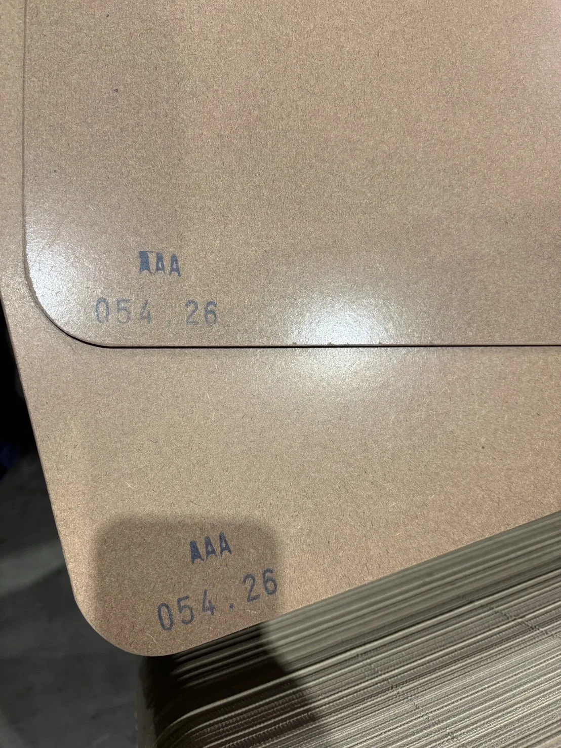 Close-up of the rounded corner and cut edge of a hardboard layer pad