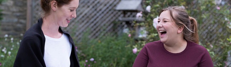 Two women talking together in a garden and laughing