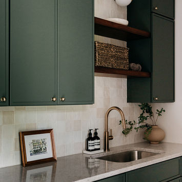 Green upper cabinetry with open shelves in laundry room — Costello & Co full service remodel