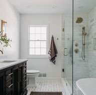 Full bathroom showing vanity, shower, and freestanding tub Full primary suite bathroom renovation with dark vanity and marble shower — Bloomfield Hills Michigan by Costello & Co Construction Oakland County
