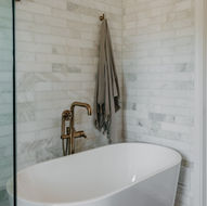 Freestanding soaking tub with marble tile background Freestanding soaking tub with marble tile — Bloomfield Hills Michigan primary suite remodel by Costello & Co Construction