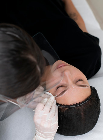 young woman performing a microblading session