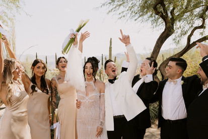 bride and groom cheering with wedding party