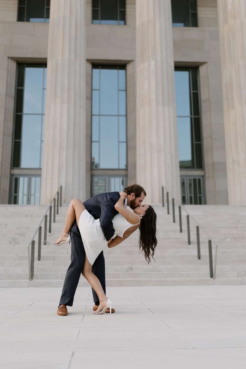 engaged couple groom dipping bride in front of Robinson theatre downtown Little Rock arkansas