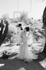 bride and groom swing on swing in front of cactus