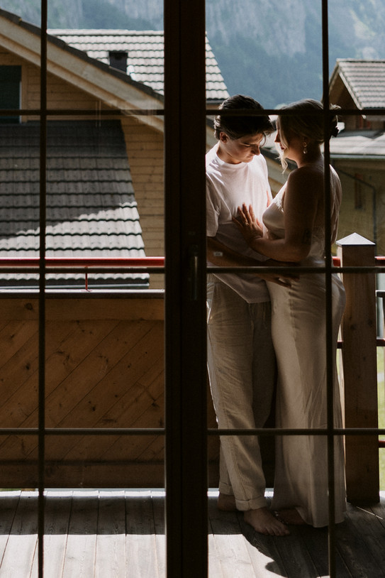 couple getting ready together in an airbnb in lauterbrunnen Switzerland on their wedding day
