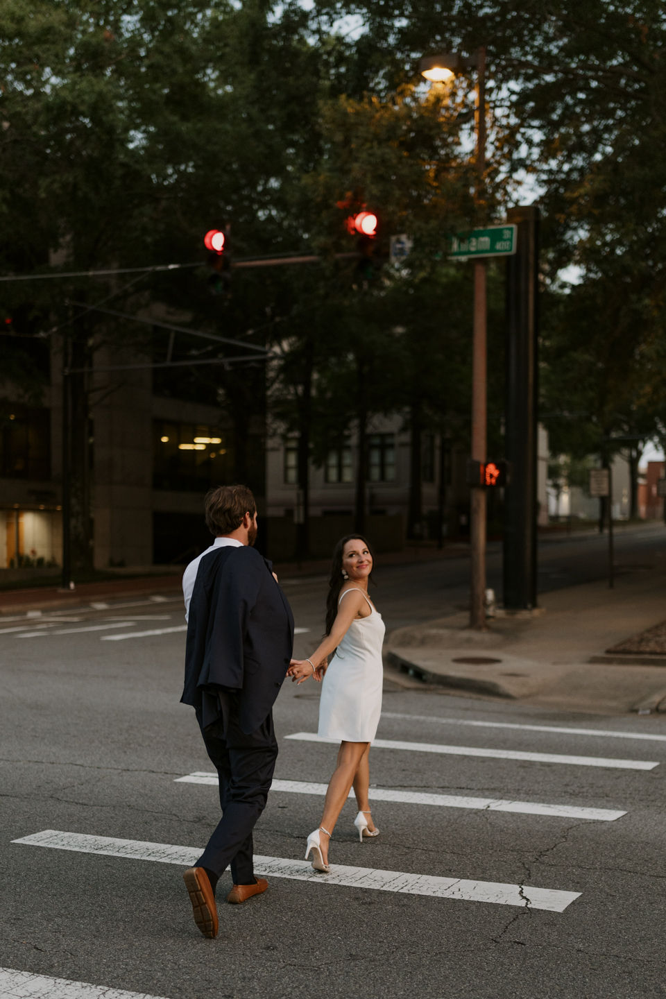 bride leading groom across the street wedding photography