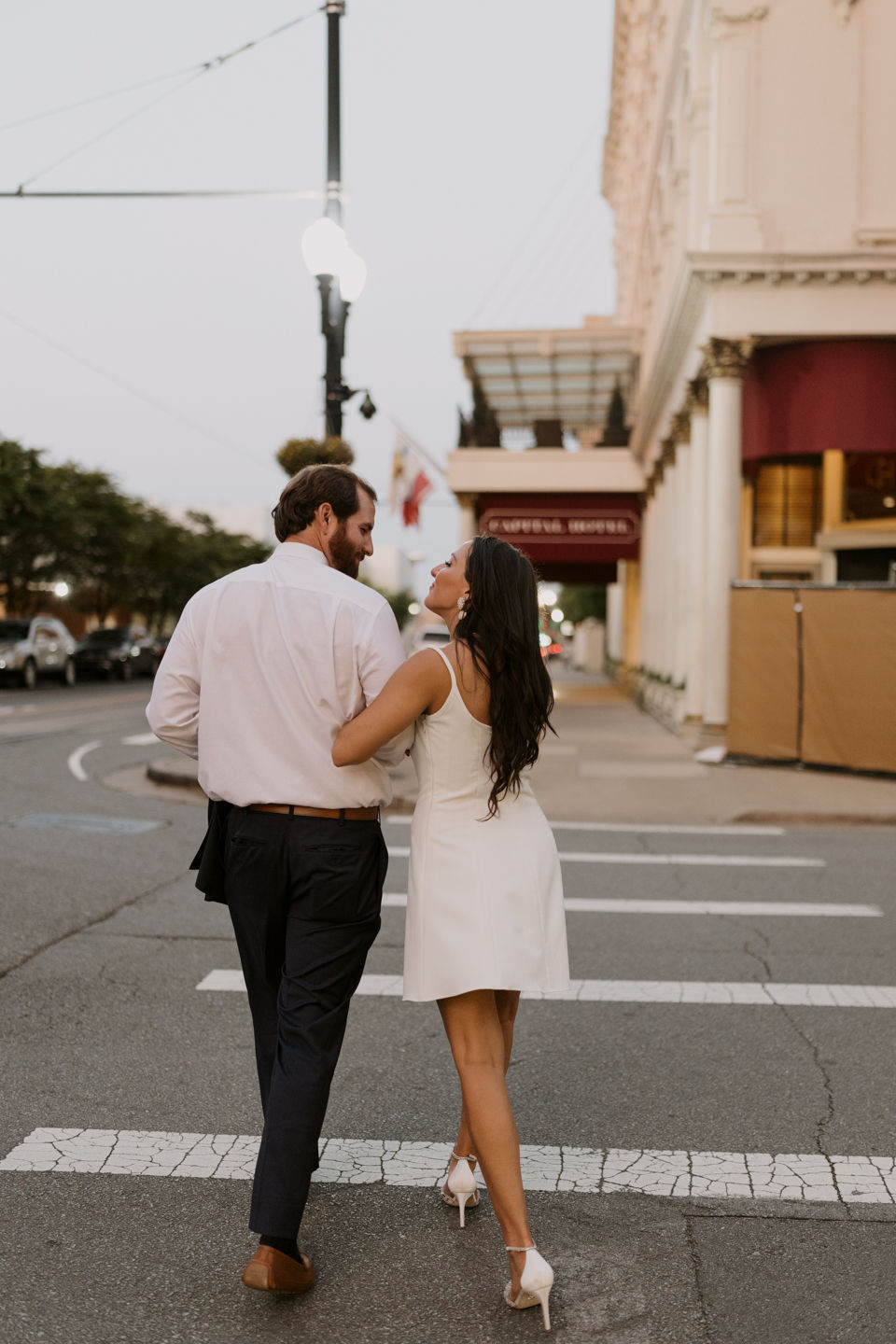engaged couple crossing the road walking to the capital hotel little rock arkansas