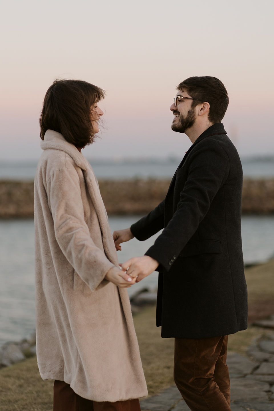 couple dance in the sunrise by a lighthouse for their engagement photos
