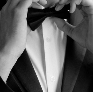 groom fixing his bow tie