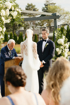 groom looks at his bride at the alter