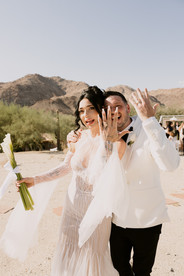 bride and groom show off their ring fingers as newlyweds