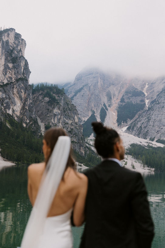 bride and groom looking out in awe of the Italian Dolomite mountains in Italy