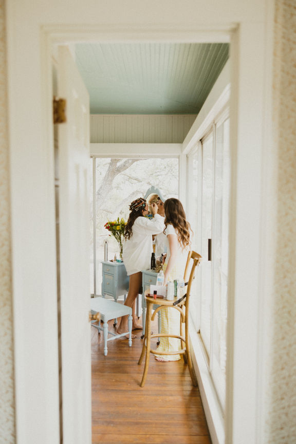 photo looking through the door of bride getting ready on her wedding day in vintage wedding venue