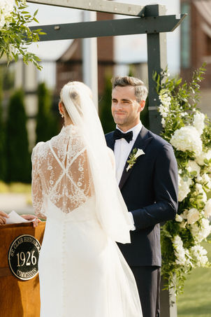 groom looks lovingly into his brides eyes at the wedding ceremony