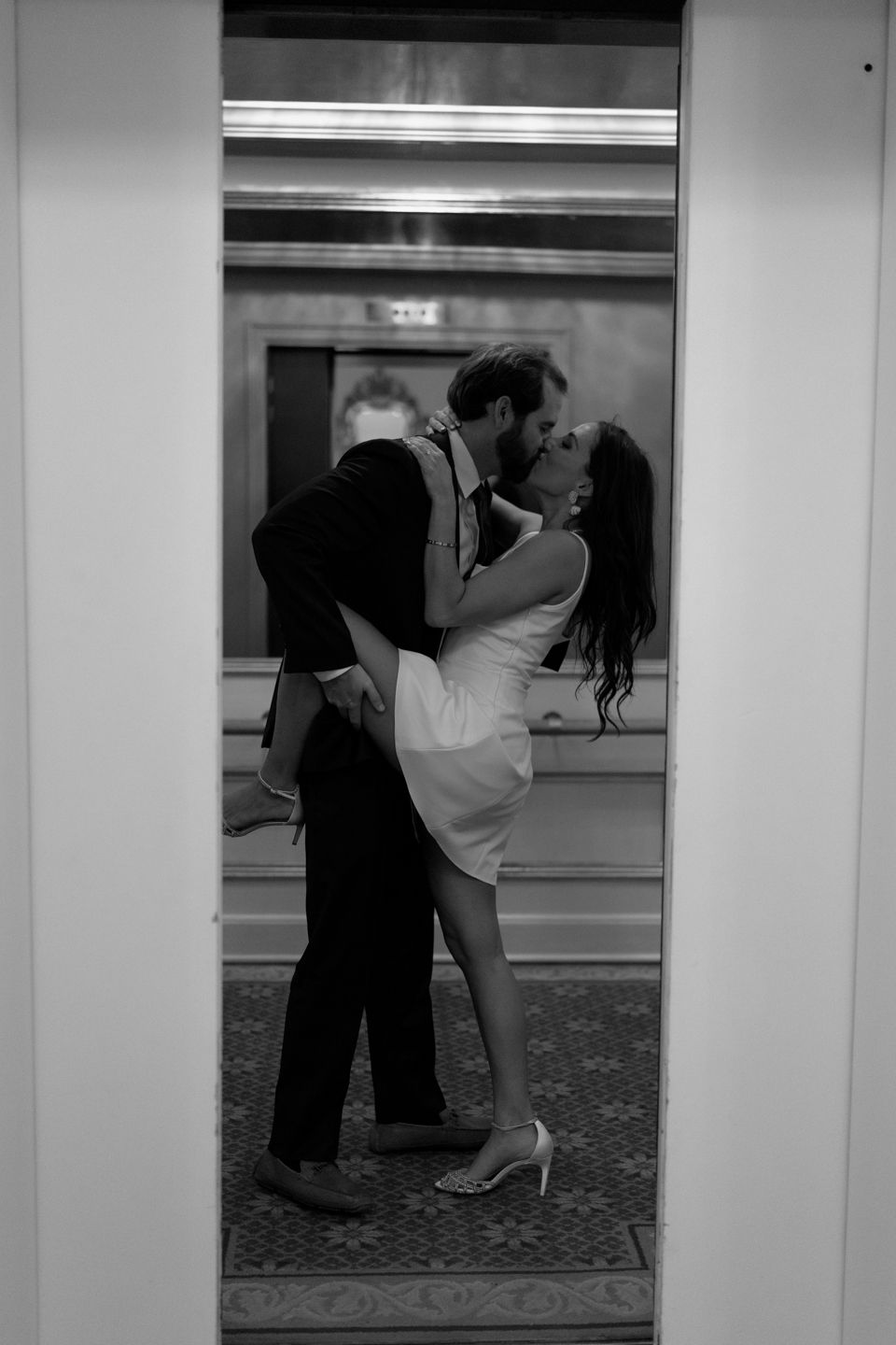 engaged couple kissing in the elevator as it shuts