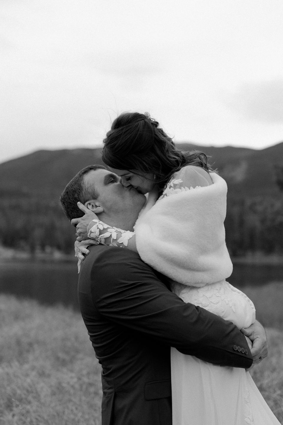 bride and groom kiss in front of the Rocky Mountains