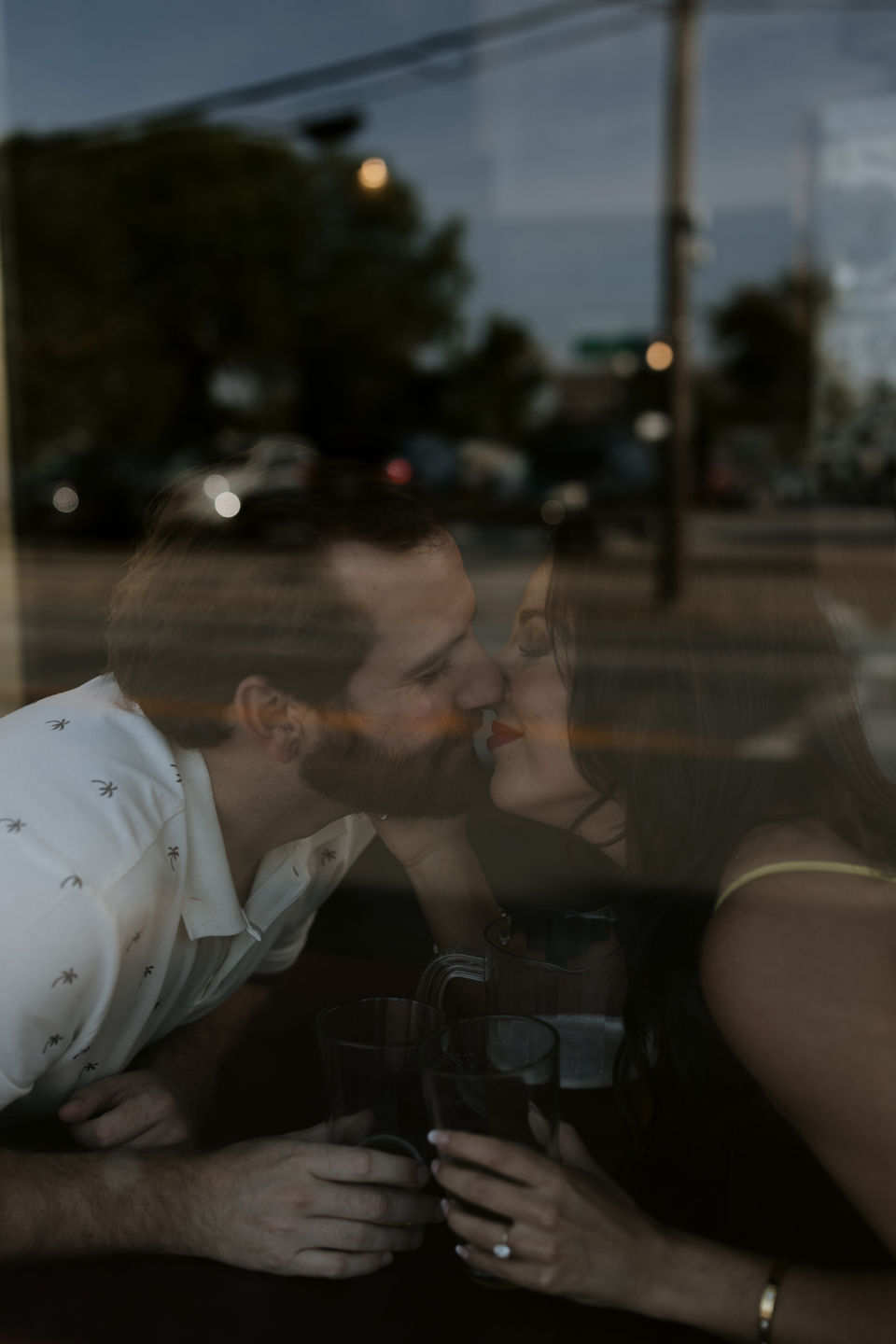 moody photo through the window of couple about to kiss