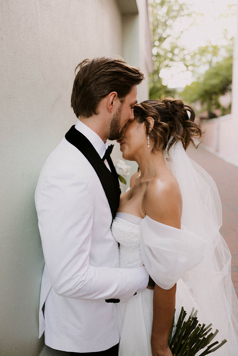bride and groom cuddling and laughing in the alleyway on their wedding day