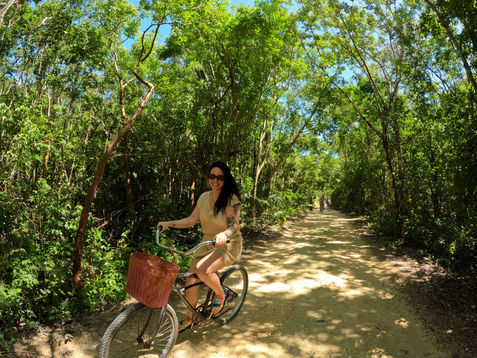 bride riding bike on her wedding day in the jungle