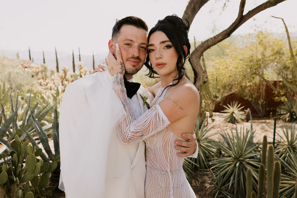 bride and groom stand in cactus garden in Palm Springs California on the day of their intimate wedding