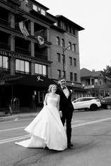 bride and groom holding hands running across the road laughing