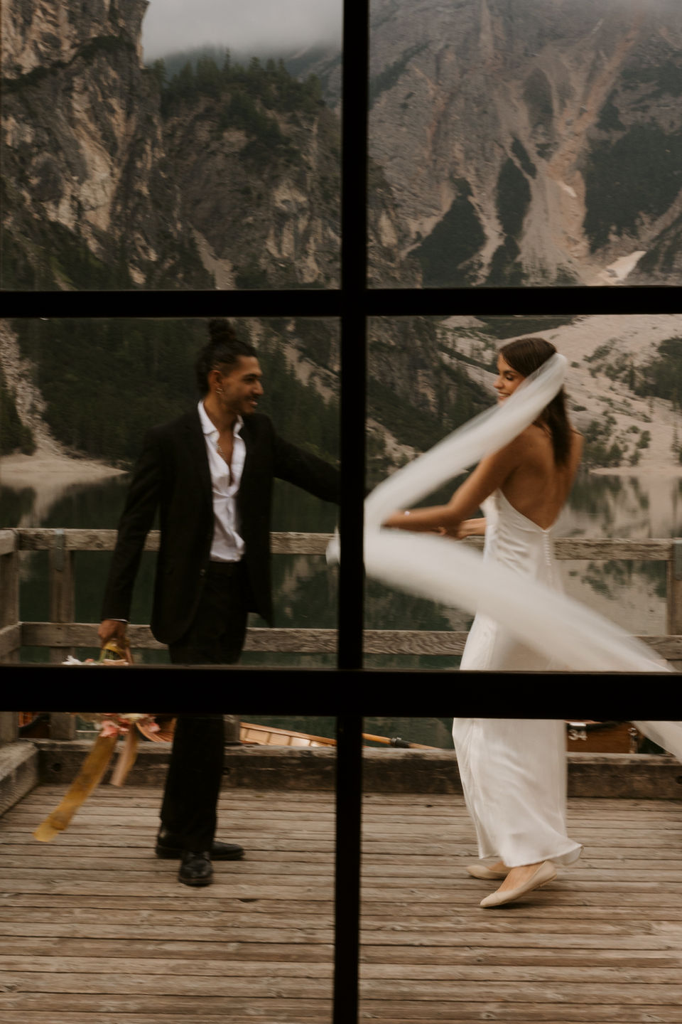 couple caught dancing together through a window pane 