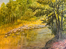 A peaceful riverside scene where golden light filters through lush trees, reflecting gently on the quiet flow of water