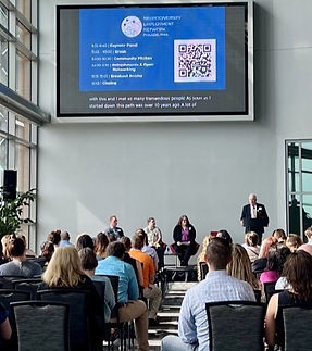 Ev and 2 other co-panelists in front of a large audience. They are giving the Keynote Panel.