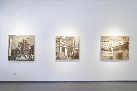 שלושה ציורי אבק תלויים בחלל הגלריה