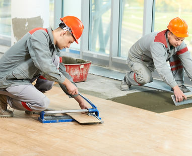 two-workers-cut-and-lay-tile-on-a-floor.jpg
