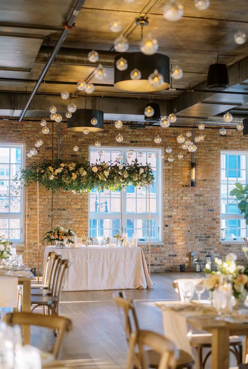 Elegant wedding reception inside Loft Lucia featuring exposed brick and floral installations