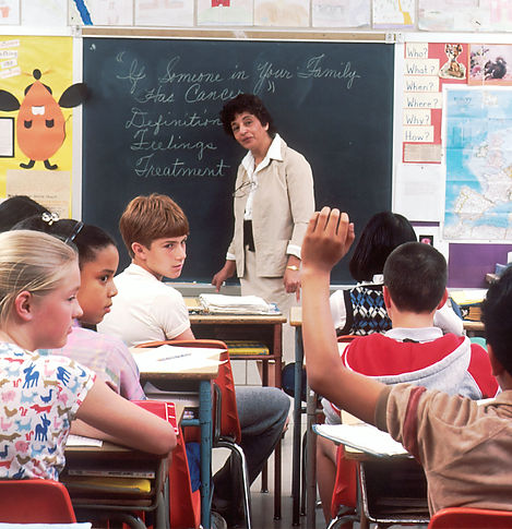 Klassenzimmer mit Lehrperson - Schüler schauen auf ein Kind.