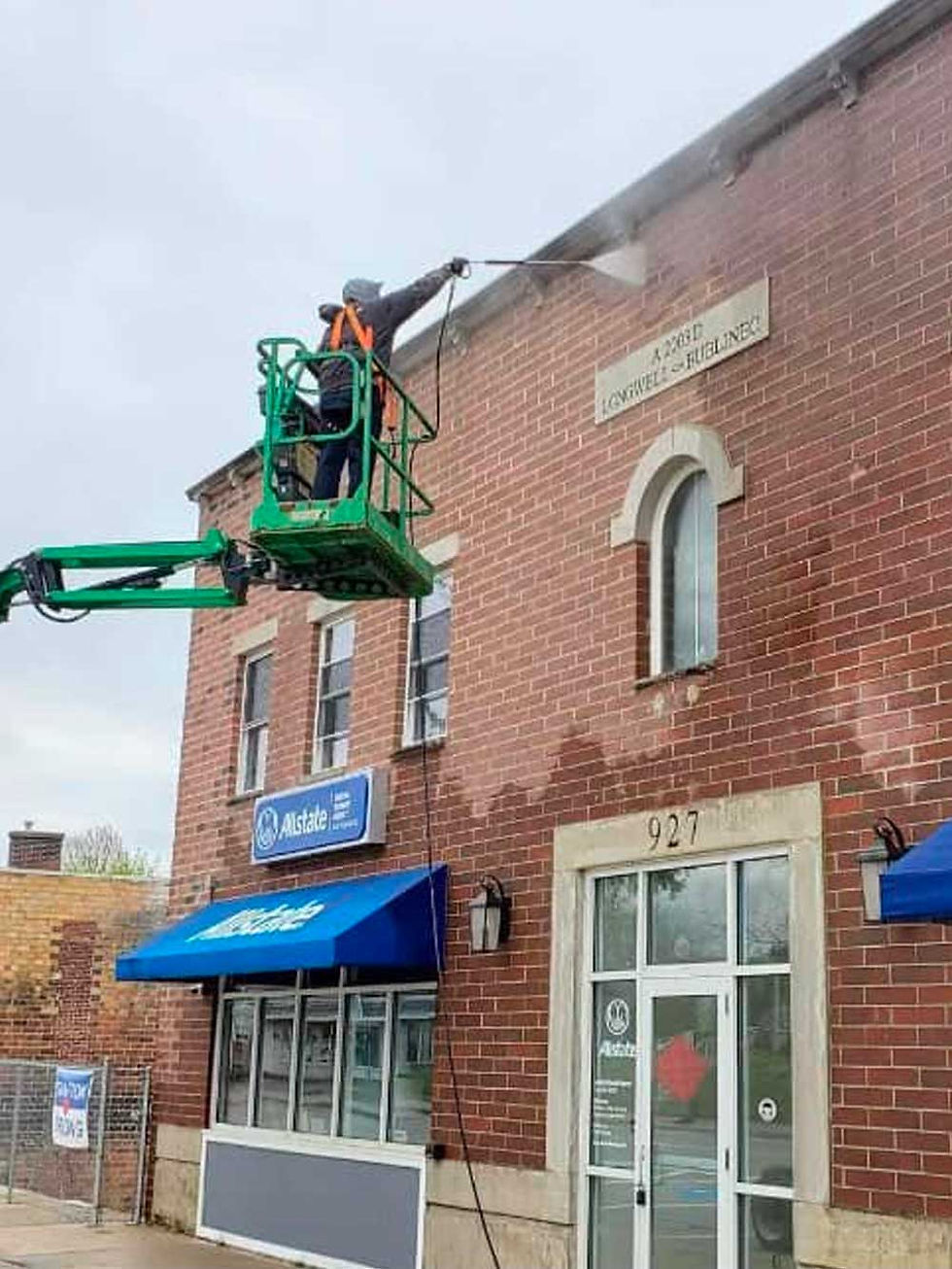 Cleaning dirt and grime from the front of a business building