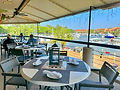 diners sitting on the waterfront balcony overlooking the marina at ELA's