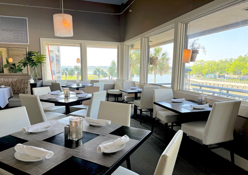 interior of ELAs waterfront restaurant with large windows overlooking the marina