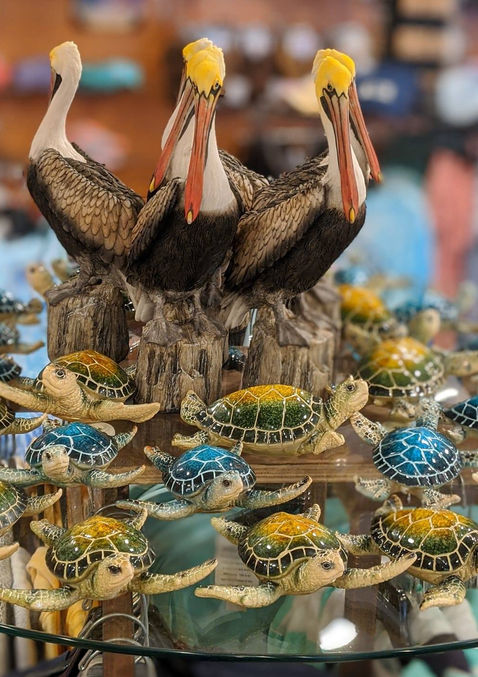 display shelf of porcelain Pelicans and turtles inside the gift shop