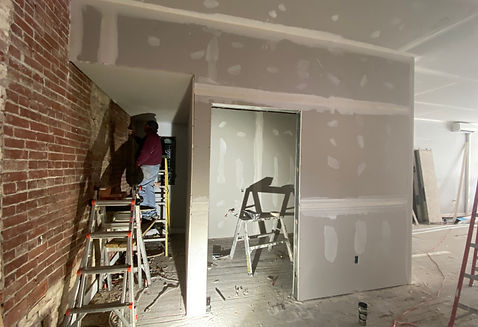 Repairing interior brick wall and drywall during storefront renovation by Oak & Co Property Services in Lancaster PA.