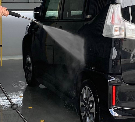 高圧の水で車両を洗う