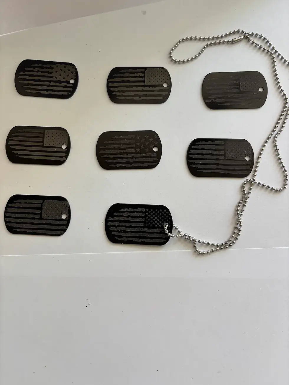 Set of black military-style dog tags engraved with assorted Distressed American-flag designs