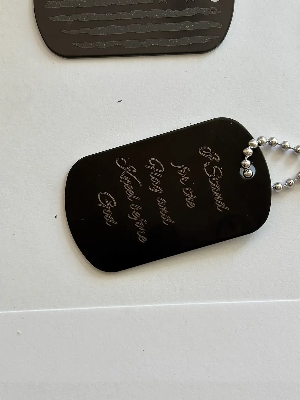Thumbnail: Back view of Distressed American-flag dog tag with custom engraved text example
