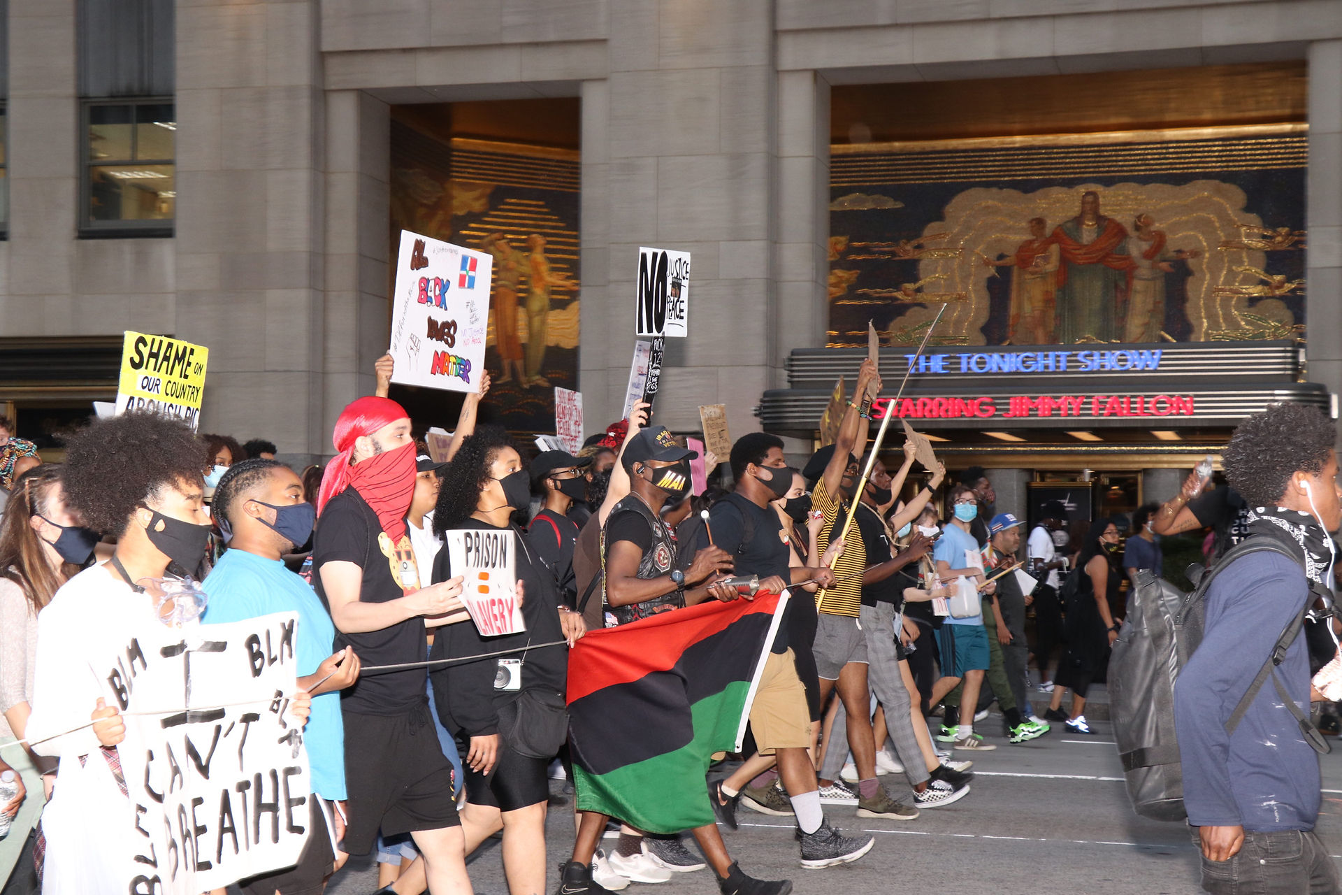 Protesters march in front of Rockefeller Center