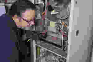 An HVAC technician working on a furnace.